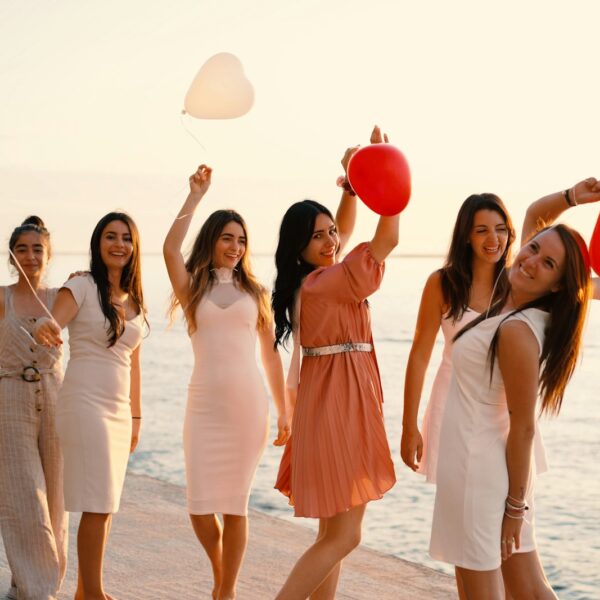 group of women standing near body of water